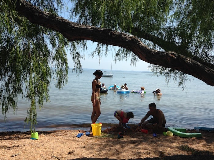 Image of Willow Points lake cabin rental guests playing in the sandy beach in front of their Texas cabin rentals. Best cabin rentals in Texas are here at our Hill Country Resort
