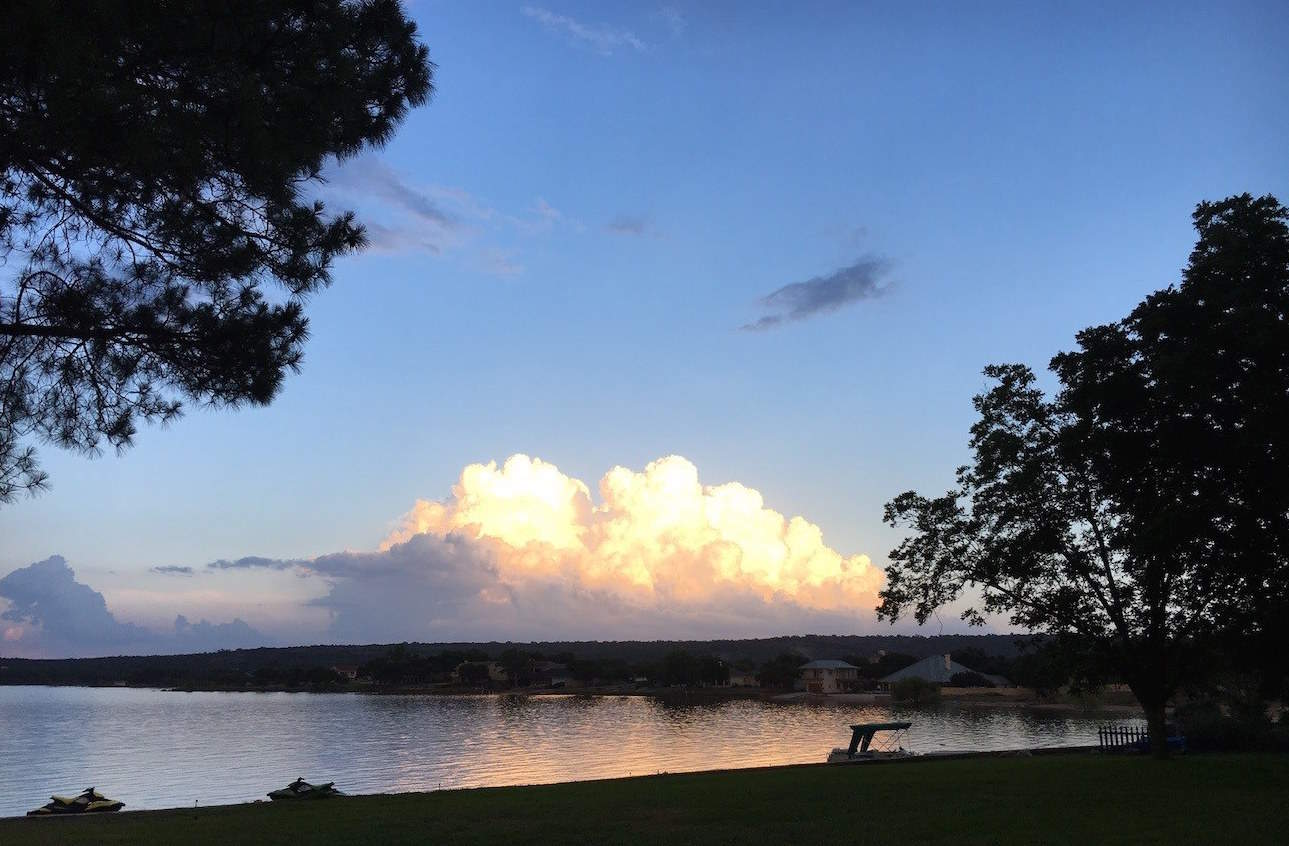 Image of sunset over Lake Buchanan in the Texas Hill Country. Our Hill Country Resort has a private lake house rental and on-site meeting room thats perfect for conferences, weddings and meetings. Relax at the best lake cabin rentals in Texas.