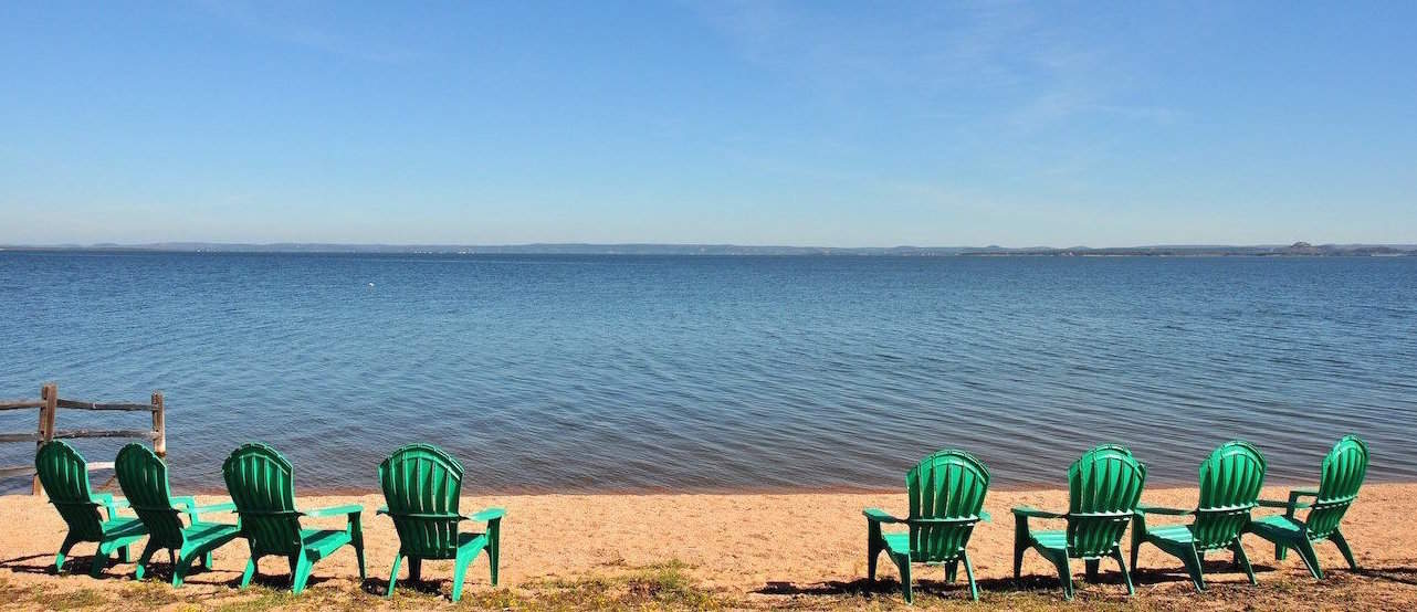 Image of beach chairs on private beach in front of lake house. Best lake house rentals in Texas. Our lake cabin rentals are situated just feet from Lake Buchanan.