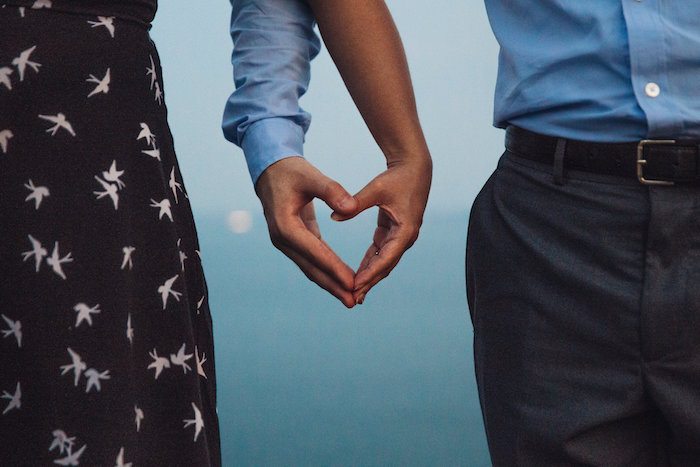 Image of couple making a heart with their hands during a romantic getaway together.Image of couple making a heart with their hands during a romantic getaway together.