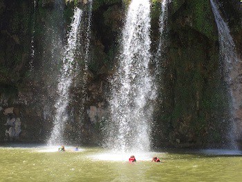 Image of guests swimming under the falls on Lake Buchanan 