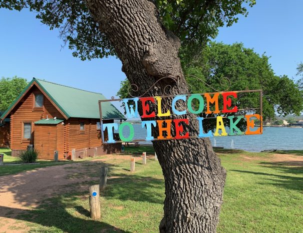 Image of the "welcome to the lake" sign at our Texas cabin rentals' resort.