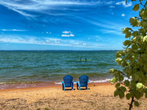 Image of guests paddleboarding from the sandy beach at our lake resort.