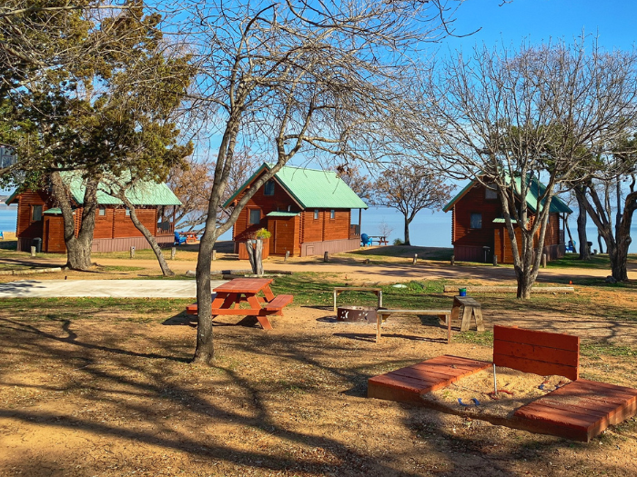 Image of the exterior of three of Willow Point Resort's lake cabins in Texas and surrounding grounds.