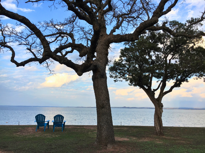 Image of two chairs facing the lake at our couples cabins in Texas resort.